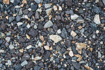 dark background of crushed granite gravel, close up.