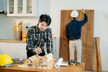 Architects and engineers collaborate on a building model, designing, planning, and measuring with...