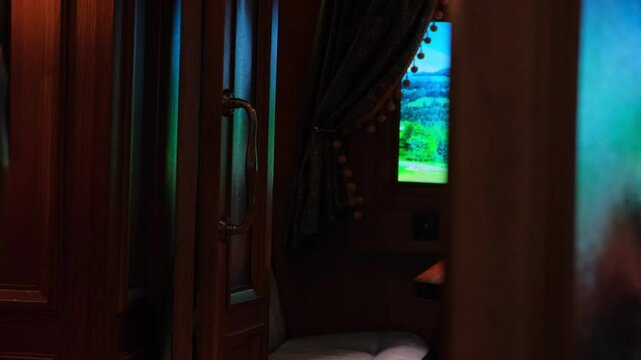 A vintage train compartment. Window view from a train traveling across the countryside mountainous area, empty. A passenger walks along the corridor