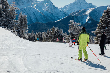 Skiers and snowboarders skiing on a snowy slope at a ski resort