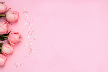 Bunch of pink roses on pink background with pink confetti
