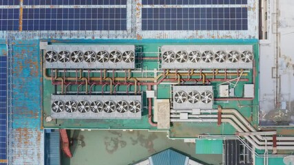 Aerial view of an industrial rooftop featuring complex HVAC systems and solar panels, showcasing modern infrastructure and energy efficiency.