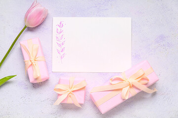 Composition with blank card, tulip and presents on light background