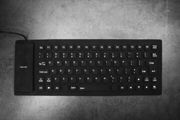 Black silicone modern computer keyboard on gray background