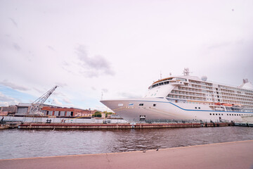 Large Cruise Liner Docked at Port Under Cloudy Skies in Urban Setting..