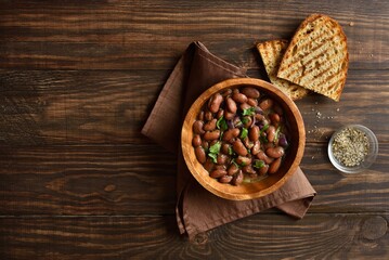 Baked beans in bowl on wooden table