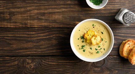 Delicious cauliflower cheese soup  over wooden background