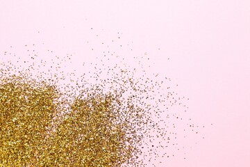 Beautiful shiny gold glitter on color background, top view