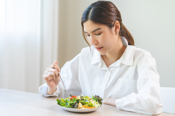 Diet in bored face, unhappy beautiful asian young woman, girl on dieting, holding fork at tomato on...