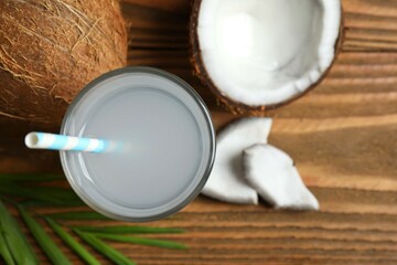 Glass of coconut water and nuts on wooden table