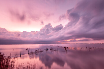 Landscape of La Albufera de Valencia in Spain at sunset with fishing nets in the foreground	