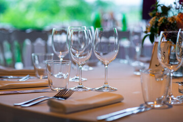 Elegant table setting with sparkling glassware and vibrant floral arrangements in bright natural light at a serene outdoor venue