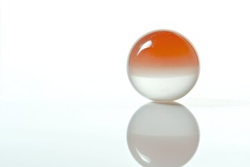 Marble with orange and white colors on a smooth reflective surface