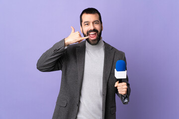 Naklejka premium Adult reporter man with beard holding a microphone over isolated purple background making phone gesture. Call me back sign