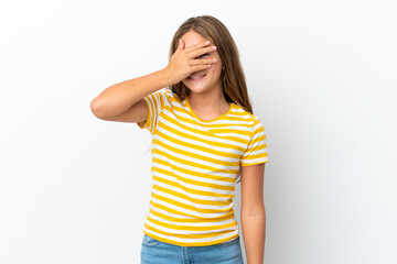Little caucasian girl isolated on white background covering eyes by hands and smiling