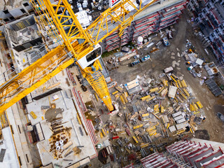 Construction site with tower cranes and building materials. Aerial view of an apartment complex under construction.