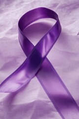 A purple ribbon lying on a piece of paper, often used as a symbol of honor or commemoration