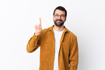 Caucasian handsome man with beard wearing a corduroy jacket over isolated white background showing and lifting a finger in sign of the best