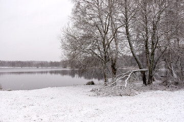 winter landscape with a lake, magical snow-covered trees and reflections in the lake, a gorgeous winter day