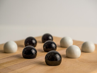 close up of black and white marbles version of tic tac toe