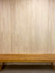 Empty Wooden Bench Against a Plain Wooden Wall in a School