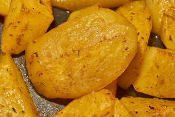 Baked potato slices with seasoning mixture. Close-up.