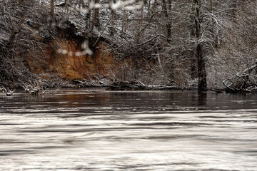 winter landscape with rapid river flow, blurred water surface, blurred movement, rapid stream of wild river, Salaca near Staicele, Latvia