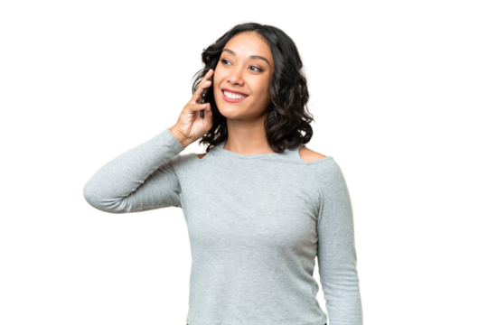 Young Argentinian woman over isolated background keeping a conversation with the mobile phone