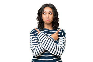 Fototapeta premium Young Argentinian woman over isolated background pointing to the laterals having doubts
