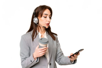Telemarketer caucasian woman working with a headset over isolated chroma key background holding coffee to take away and a mobile