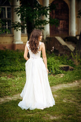 Fototapeta premium Stunning bride gracefully poses in a spring park, among blossoming trees. exuding elegance,