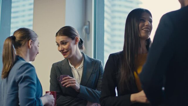 Businesswoman gossiping about a colleague during an office coffee break. Concept of workplace rumors, office politics, jealousy, envy, informal conversations in a corporate setting