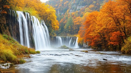 Autumn waterfall cascading into river, vibrant fall foliage, misty mountains in background.  Possible use nature, travel, or tourism brochure