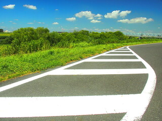 真夏のゼブラゾーンのある江戸川土手のサイクリング道路風景
