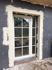 Renovation progress showcases a modern door installation in a rustic setting