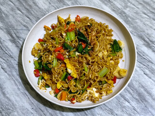 Fried egg noodles served with chili, vegetables and fried onions.