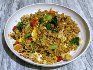 Fried egg noodles served with chili, vegetables and fried onions.
