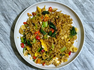 Fried egg noodles served with chili, vegetables and fried onions.
