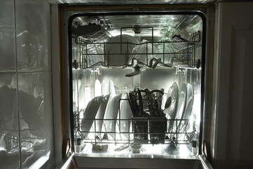Full dishwasher built into white kitchen cabinet backlit