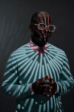 Portrait of Man Standing Under Shadow Pattern Wearing Suit