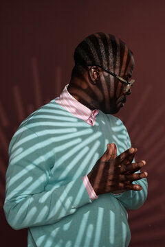 Contemplating Man Behind Shadowed Light Stripes Indoors