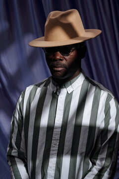 Portrait Of Man Wearing Hat And Striped Shirt Looking Confident