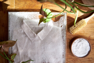 white shirt lies in water with foam, the concept of eco-friendly washing