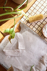white shirt lies in water with foam, the concept of eco-friendly washing