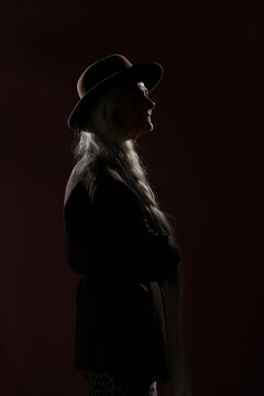 Silhouetted Profile of Elderly Woman Wearing Hat