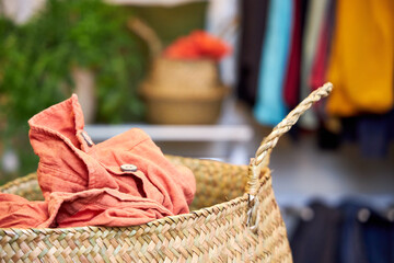 A wicker basket of clothes is on a table in the dressing room