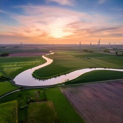 Obraz premium A serene drone shot of a winding river cutting through a vast, flat plains landscape, with sunset on the horizon