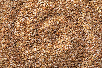 Flat background of crushed buckwheat groats