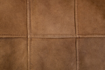 Fototapeta premium Suede genuine leather stitches grid, brown color animal skin for clothes manufacturing , abstract backdrop