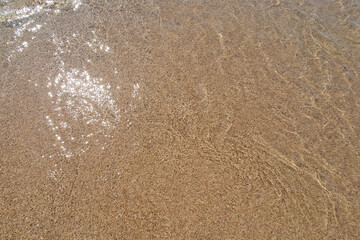 Sand in the summer day. Yellow sand on the beach near a sea.